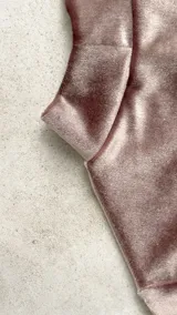 Body de terciopelo marrón con estampado de piel de serpiente, cuello alto, mangas largas con orificio para el pulgar y espalda descubierta.