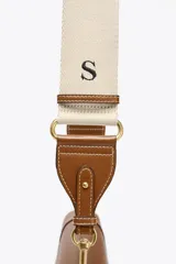 Bolso de hombro ovalado negro con asa de doble tira redonda con detalles metalizados dorados. Cierre imantado y asa de bandolera extraíble con tejido a contraste. Bolso interior con cierre mediante cremallera metálica.