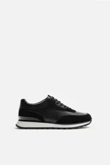 Zapatilla deportiva negra con detalles en piel y acabado serraje.