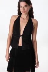 Top negro con escote halter y espalda descubierta, confeccionado en cuero.