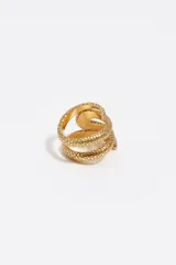 Anillo de metal plateado con diseño de serpiente en espiral y textura de escamas detallada.