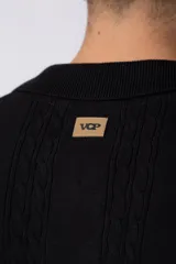 Camisa de tejido de punto color beige, con cuello tipo bowling, manga corta y corte relajado. Cierre frontal con botones.