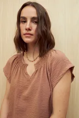 Blusa color ladrillo con escote en V y mangas cortas.