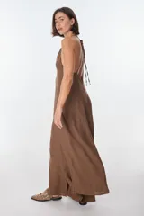 Conjunto de top halter con abertura en el abdomen y falda cruzada con ruedo desflecado, color fucsia.