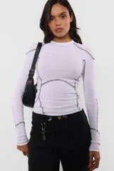 Top manga larga de morley color lila, con cuello redondo y detalle de costuras a contratono.