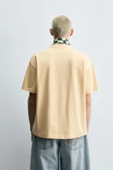 Camiseta color arena de algodón compacto, corte recto, cuello redondo y mangas cortas.