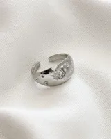 Anillo plateado ajustable de acero con diseño de estrellas y círculos.