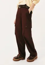 Pantalón cargo color borgoña, de corte recto, con bolsillos laterales con solapa y cinturón trenzado marrón.