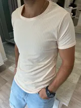 Remera color beige de corte ajustado y cuello redondo.