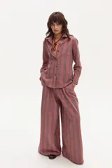 Pantalón de corte culotte con cintura alta y pierna ancha, confeccionado en lino con estampado de microcuadros en tonos rojo y negro.