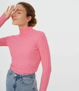 Polera verde de punto acanalado, con cuello alto y mangas largas.