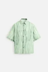 Camisa verde agua con estampado abstracto, corte relaxed fit, cuello solapa, manga corta y cierre frontal con botones.