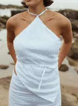 Top blanco de lino con escote halter y lazo en la cintura.