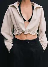 Short negro de lino con tiro medio, trabillas, cierre frontal con cremallera y botón, detalle de pinzas, cinturón con hebilla, diseño corto y recto, y dos bolsillos laterales.