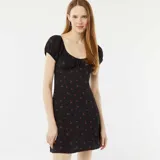 Vestido corto negro con estampado de flores rojas, escote cuadrado, mangas cortas abullonadas y cuerpo ajustado de tejido gofrado.