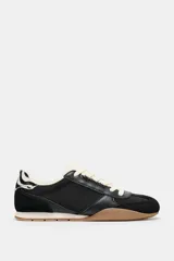 Zapatillas deportivas negras con detalle de estampado animal en la parte trasera, suela color caramelo y ajuste con cordones.