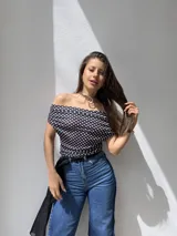 Top negro con lunares blancos, escote off-shoulder y mangas cortas.