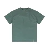 Remera de manga corta color verde azulado, con cuello redondo y corte holgado. Presenta un pequeño tag blanco cosido en el ruedo inferior.