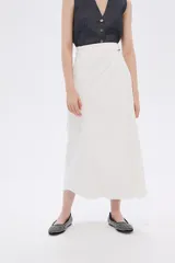 Falda midi de jean color blanco, con corte evasé y ruedo desflecado.