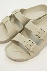 Sandalias tipo Birkenstock color beige con hebillas ajustables.