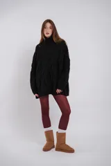 Buzo de lana trenzado en color negro, con cuello alto y diseño oversize.