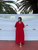 Vestido largo rojo de lino, con escote en V y corte en forma de U debajo del busto. De corte amplio y mangas cortas.