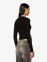Top de manga larga ajustado al cuerpo, confeccionado en punto elástico acanalado, color negro. Presenta cuello alto y un pequeño logo bordado en el centro del pecho.