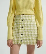 Falda corta de tweed con cierre frontal de botones.