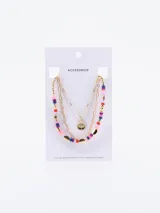 Set de tres collares dorados de diferentes largos. Uno es una cadena de eslabones, otro es una cadena de bolitas doradas y el tercero es una cadena fina con bolitas y un dije redondo con una inscripción.