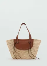 Bolso tipo canasta de fibras naturales color beige, con solapa y asas de cuero marrón.