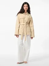 Chaqueta de algodón color arena, con cuello extendido, cierre con botones y cinturón para atar en la cintura.