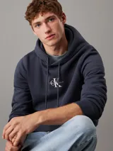 Buzo de felpa azul marino con capucha y cordones ajustables. Logotipo de Calvin Klein Jeans estampado en el pecho.