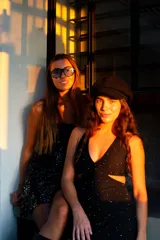 Vestido corto negro con estampado de hojas doradas, escote en V, breteles finos cruzados en la espalda, cut-outs laterales bajo el busto y volado en el ruedo.