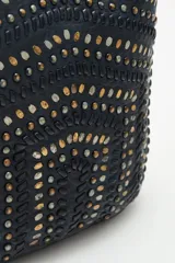 Cartera tote negra de cuero vacuno con tachas metálicas plateadas y doradas. Tiene doble asa corta y correa larga desmontable. Forro interior de algodón.