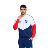 Buzo de frisa azul marino, blanco y celeste con cuello redondo, puños y cintura acanalados. Presenta el logo de Umbro bordado en blanco en el pecho izquierdo, el escudo del Club Nacional de Football bordado en el pecho derecho y una cinta con diseño geométrico en los hombros.