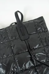 Bolso tipo shopper acolchado color gris metalizado, con cierre superior y doble asa de hombro en color gris claro.