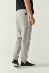 Pantalón de jogging negro de felpa con puños y cintura ajustable con cordón. Presenta logo de goma en la pierna izquierda y bolsillos laterales.