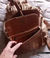 Mochila de cuero color camel con solapa con flecos y cierre con cordón de cuero.