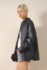 Camisa de cuero ovino color negro, de calce holgado y terminación arrugada. Tiene snaps metálicos color plata vieja con logo de la marca grabada.