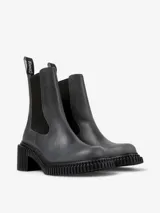 Bota de media caña color gris oscuro, confeccionada en piel vacuna, con paneles elásticos laterales, tirador trasero y suela XL EXTRALIGHT. Tiene un tacón de 7 cm con diseño acanalado.