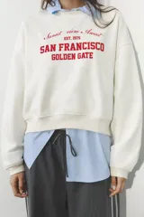 Sudadera azul marino de cuello redondo y manga larga con estampado frontal que dice "New South Wales Sydney 1985 Bondi Beach" en color blanco.