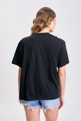 Remera negra de manga corta con nudo en el hombro.