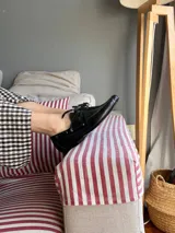 Mocasines de cuero negro con cordones finos y suela plana.