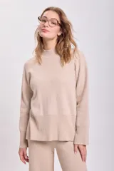 Sweater de punto color beige, con cuello alto y mangas largas.