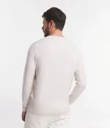 Suéter de punto color borgoña, con cuello redondo, sisas ligeramente desplazadas y bajo y puños acanalados.