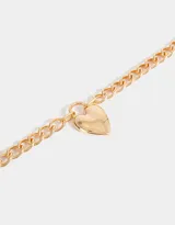 Collar corto dorado con cadena de eslabones gruesos y dije de corazón estilo chunky.