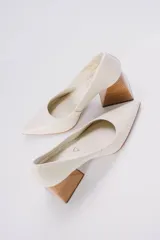 Zapatos de tacón color mostaza de cuero, con punta fina y tacón cuadrado forrado en cuero tipo madera.