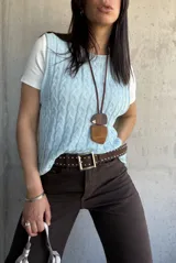 Chaleco celeste de hilo con diseño de trenzas.