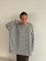 Sweater de punto a rayas horizontales blancas y negras, de corte holgado y mangas largas.