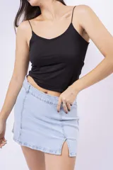 Minifalda de jean de tiro alto, color celeste claro lavado, con roturas sutiles y aberturas frontales en el ruedo.